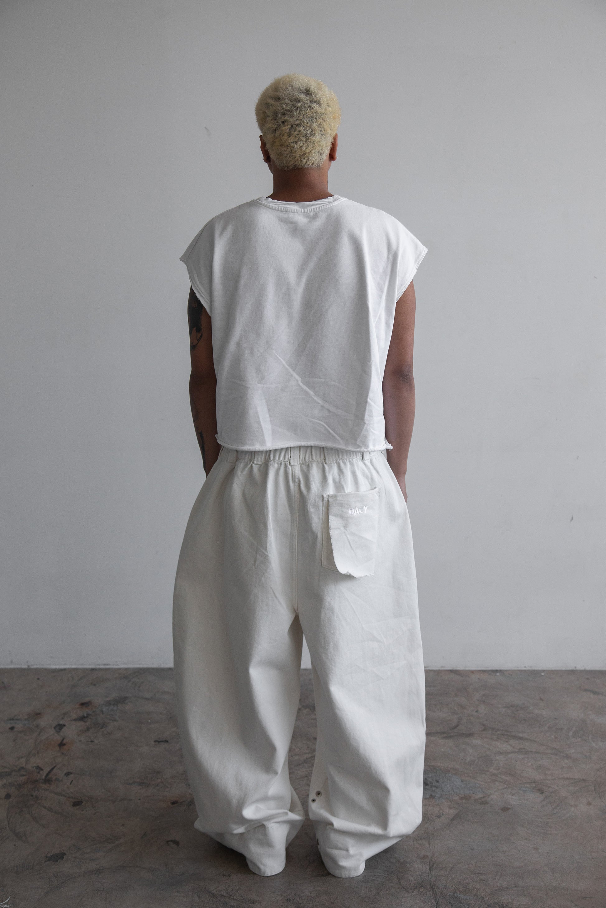 Uniform Pants in off-white cotton drill with oversized unisex fit, elastic drawstring waist and rear patch pocket.