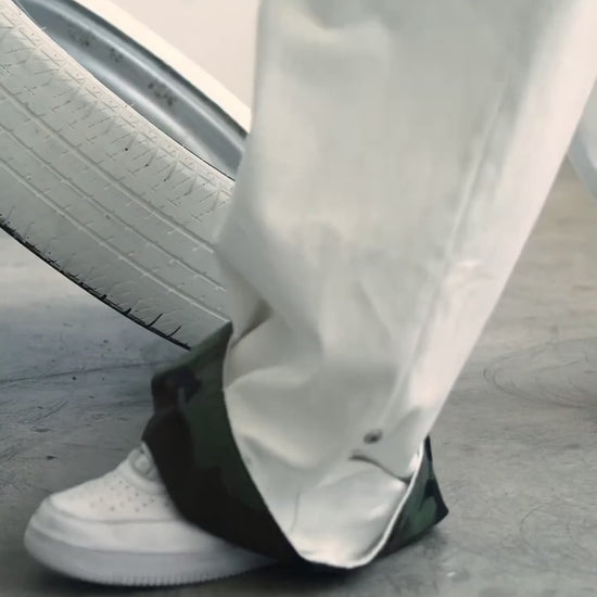 Video showing the adjustable clip-up hem on the DACY Studio Uniform Pants, transforming the off-white oversized pants to reveal the camouflage lining.