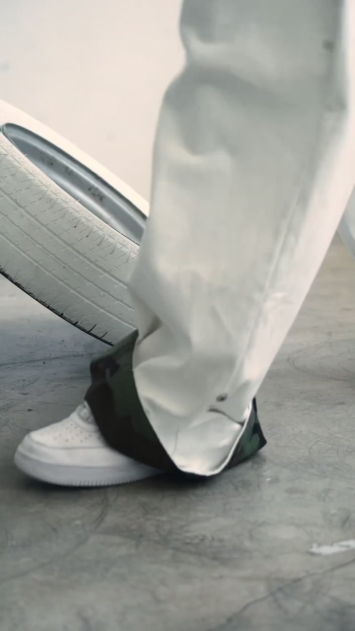 Video showing the adjustable clip-up hem on the DACY Studio Uniform Pants, transforming the off-white oversized pants to reveal the camouflage lining.
